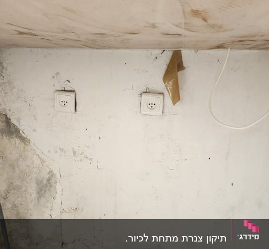 קיר עם שקעים חשמליים וסימני רטיבות